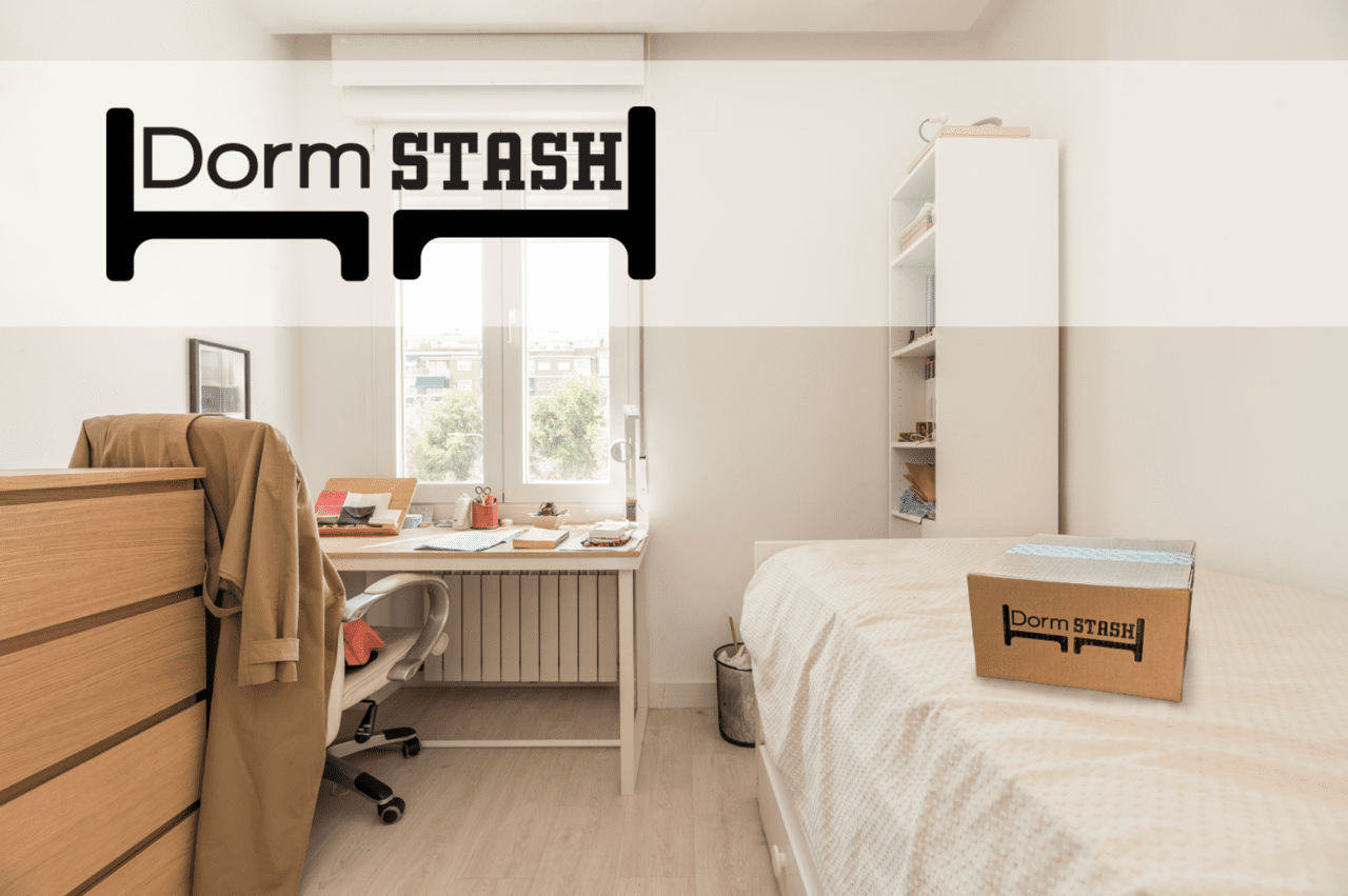A tidy dorm room with a bed, desk, chair, and dresser. A Dorm Stash box is on the bed. The Dorm Stash logo is displayed in the top left corner.